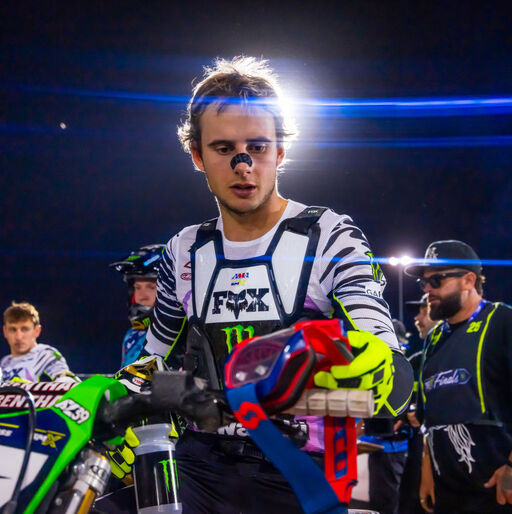 Levi Kitchen grabbing goggles of dirt bike handlebar